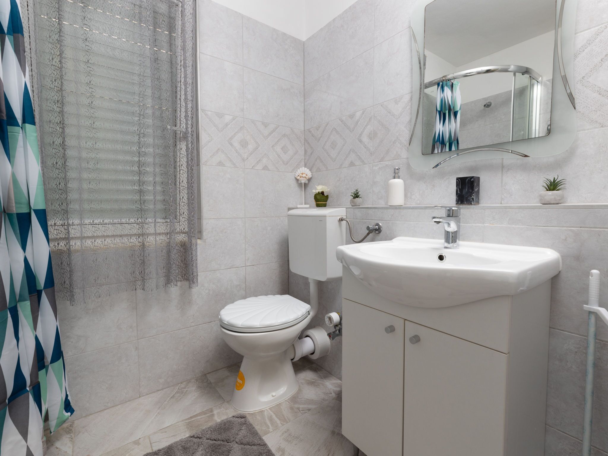 A bathroom with a toilet, sink, and shower area.