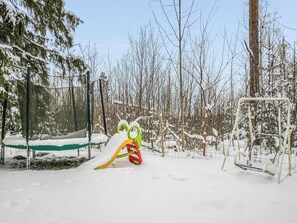 Un parque cubierto de nieve con un tobogán y una estructura para escalar.