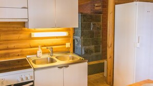 Une cuisine de taille réduite, équipée d’une cuisinière, de deux éviers et d’un réfrigérateur.