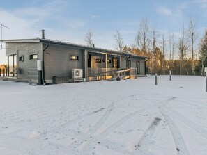 En toetagers bygning med en overdækket veranda, en stor aircondition og nummer '558' på siden.