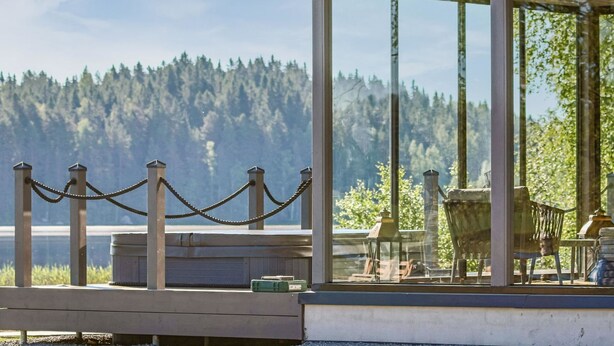 A wooden deck with a view of a forested hillside.