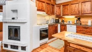 Une cuisine avec des meubles de rangement en bois, une cuisinière blanche, un four à micro-ondes et une machine à café.