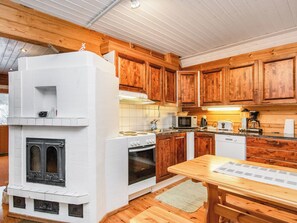 Una cocina con armarios de madera, estufa blanca, microondas y cafetera.