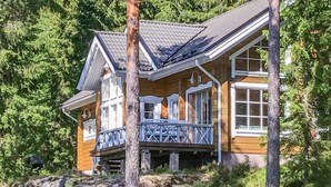 A wooden cabin with a balcony, surrounded by trees and rocks. - Näsinjoutsen by Interhome (Ruovesi)