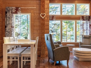 Un interior de madera con una mesa de comedor, sillas y un sofá.