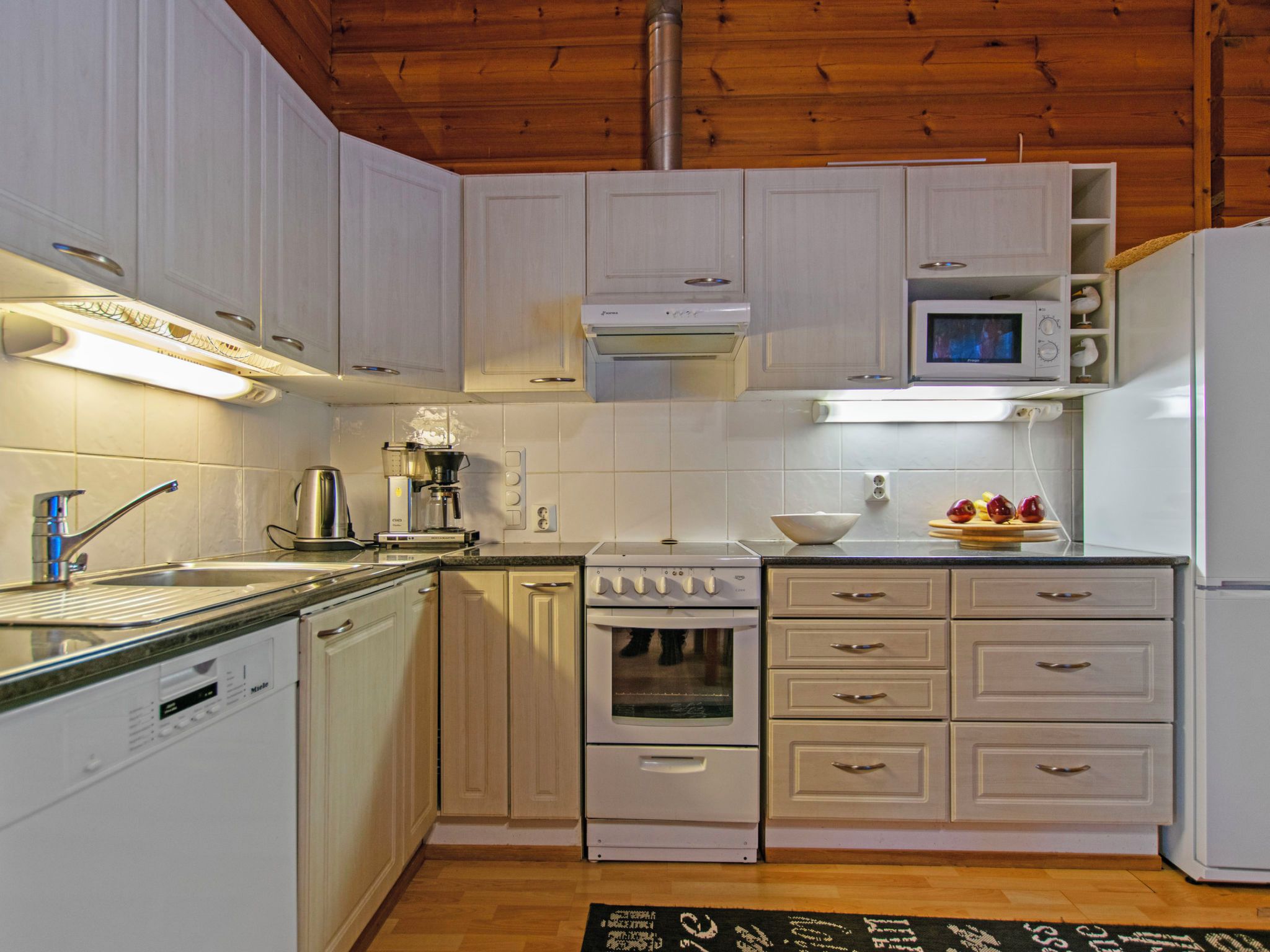 A kitchen with white cabinets, a stove, a microwave, and a dishwasher.