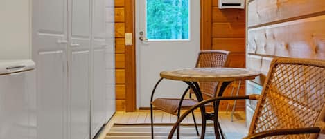 Een houten interieur met een deur, een raam en een tafel met stoelen.