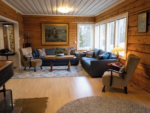 A cozy living room with a sofa, armchairs, a coffee table, and a painting on the wall. - Villa rauhala by Interhome (Sastamala)