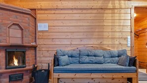 Una habitación acogedora con chimenea, un sofá de madera y una mesa con dos individuales.