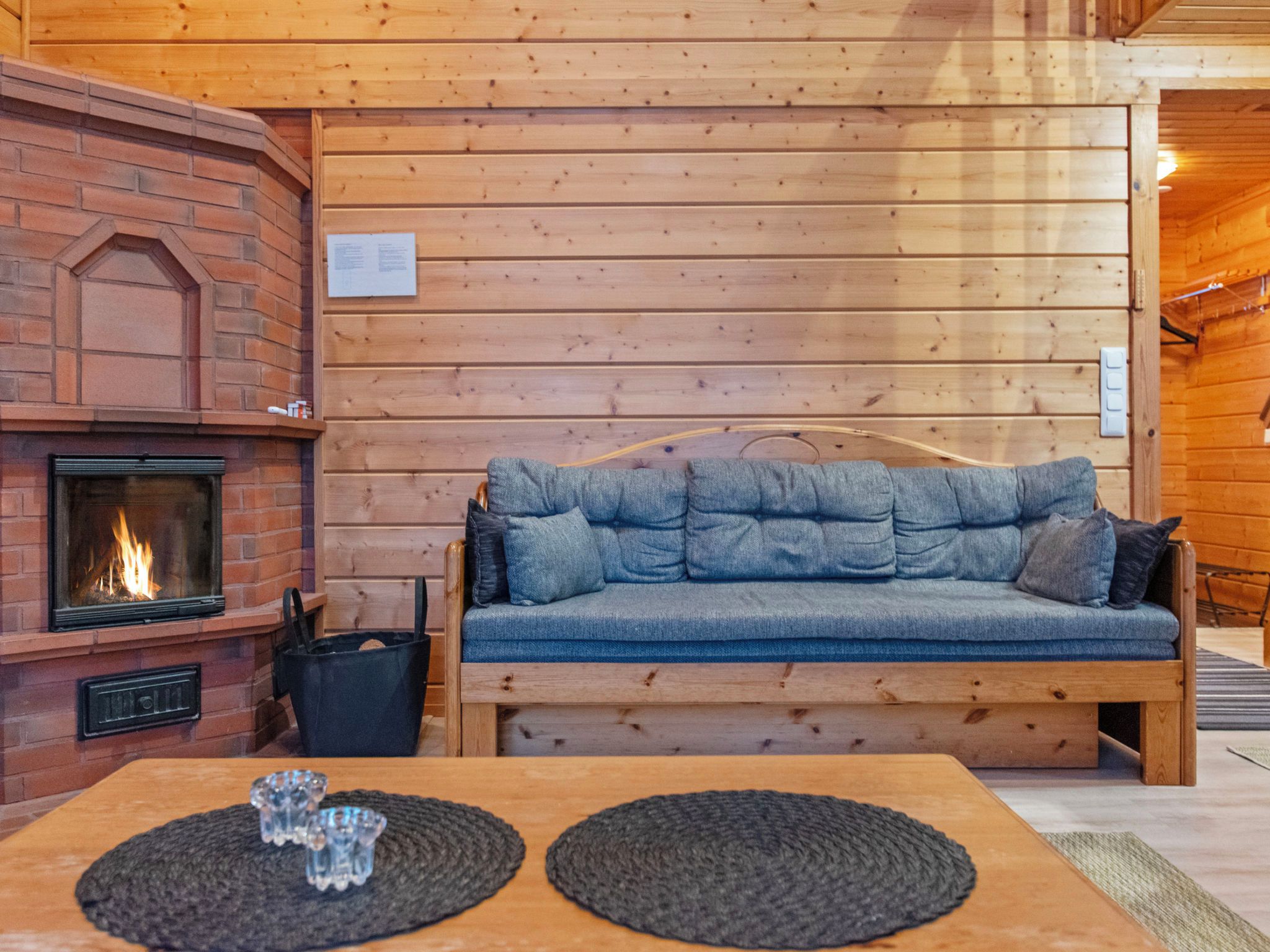 Ein gemütliches Zimmer mit Kamin, einer Holzbank und einem Tisch mit zwei Platzsets.