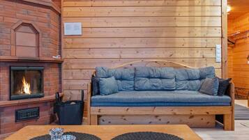 Ein gemütliches Zimmer mit Kamin, einer Holzbank und einem Tisch mit zwei Platzsets.