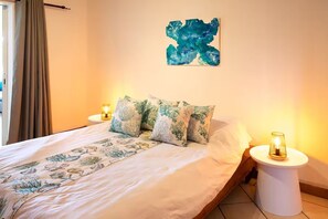 Cozy retreat with a large bed, bedside table, and unique art piece.