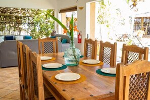 Enjoy meals in this dining area with a table for six, surrounded by comfortable chairs and a beautiful view of the outdoor pool.