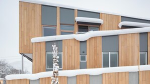 A modern building with wooden paneling and large windows.