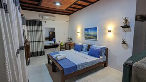 A bedroom with a wooden bed, a nightstand, a mirror, and a wall-mounted shelf with a statue. - Jennifers Villa, Make your soul full in Love and Peace in Negombo AC,Wifi,Beach (Negombo)