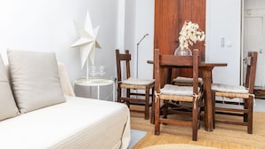 A modern living room with a sofa, wooden chairs, a dining table, and a decorative star.