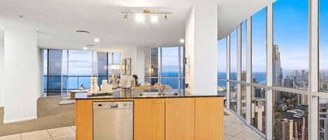 Una cocina moderna con una isla central, ventanas amplias y vista a la ciudad.