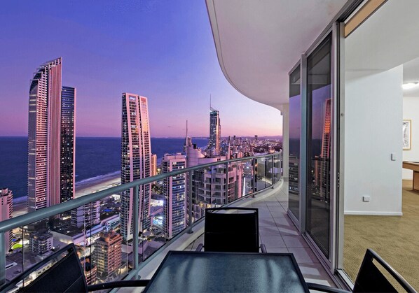 A balcony with a city view at dusk, featuring modern high-rise buildings and a clear sky. - Level 45 Luxury Sub-Penthouse in Surfers (Surfers Paradise)