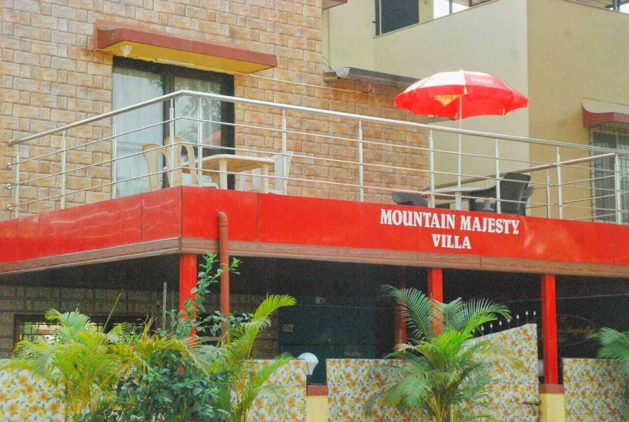 A building with a red facade and the name "MOUNTAIN MAJESTY VILLA" prominently displayed.