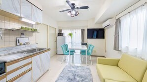 A modern kitchen with a marble countertop, a ceiling fan, and a dining area with a table and chairs. - New Ueno Station 7 Min Walk Inarimachi (Tokyo)