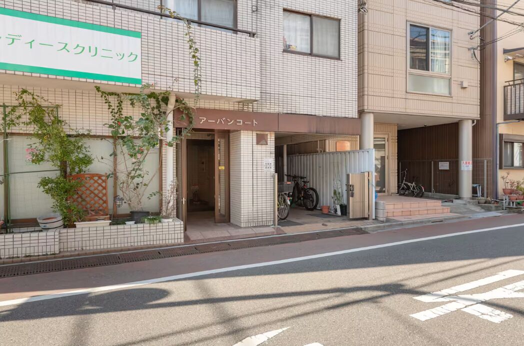 Un edificio con un letrero que dice "Aeban Court" y una bicicleta estacionada afuera.