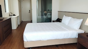 A hotel room with a large bed, wooden flooring, a desk with a lamp, and a wardrobe. - SEDONA Hotel Viet Yen (Viet Yen)