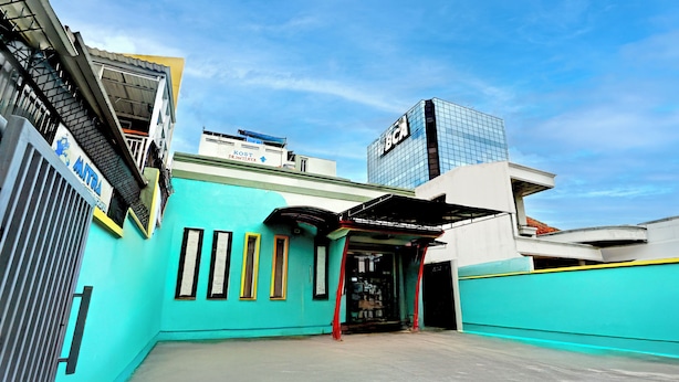 A building with a blue facade, a covered entrance, and a sign for BCA. - Hotel O Tegalsari Near Tunjungan Plaza (Surabaya)