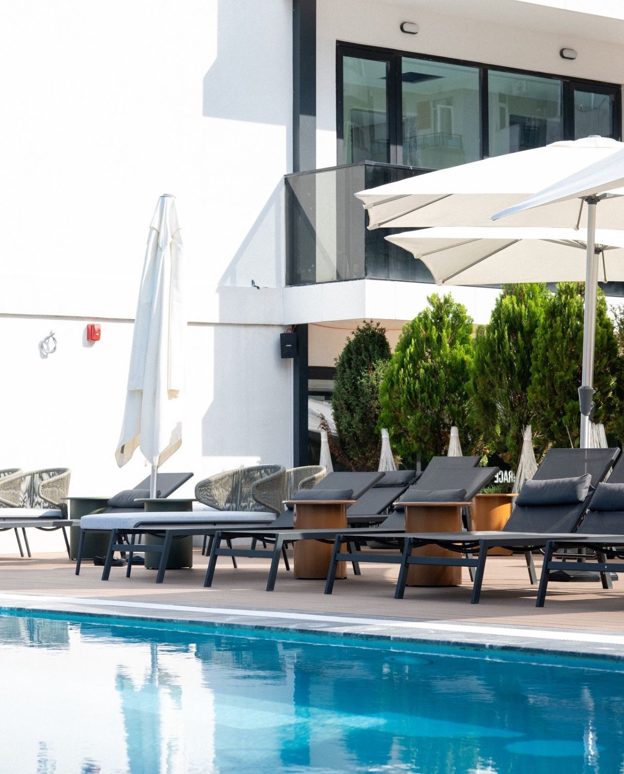 Una piscina al aire libre de temporada, sombrillas