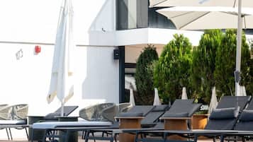 Una piscina al aire libre de temporada, sombrillas