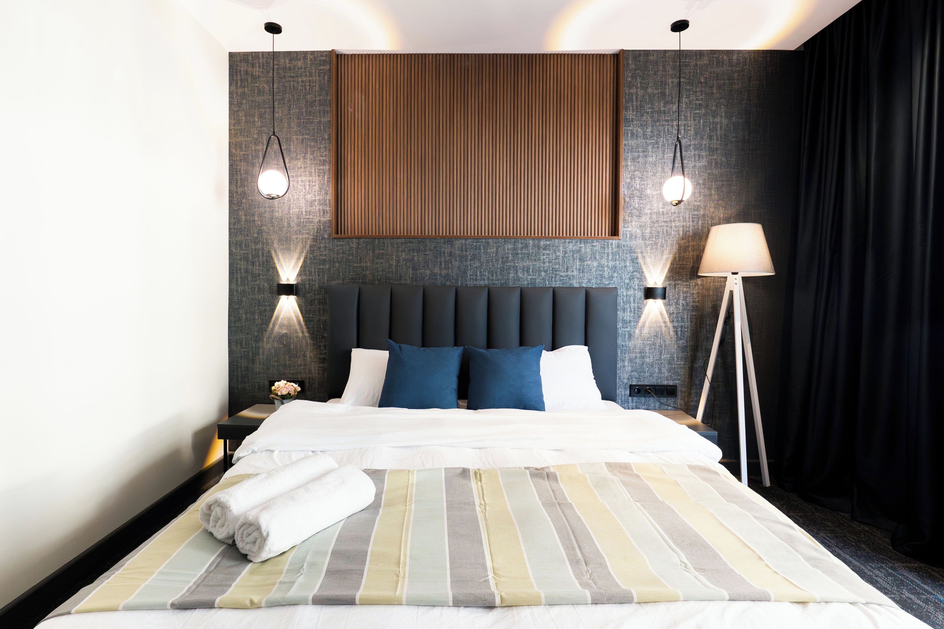 Une chambre d’hôtel avec un grand lit, deux lampes de chevet, une table de chevet et une lampe sur pied.