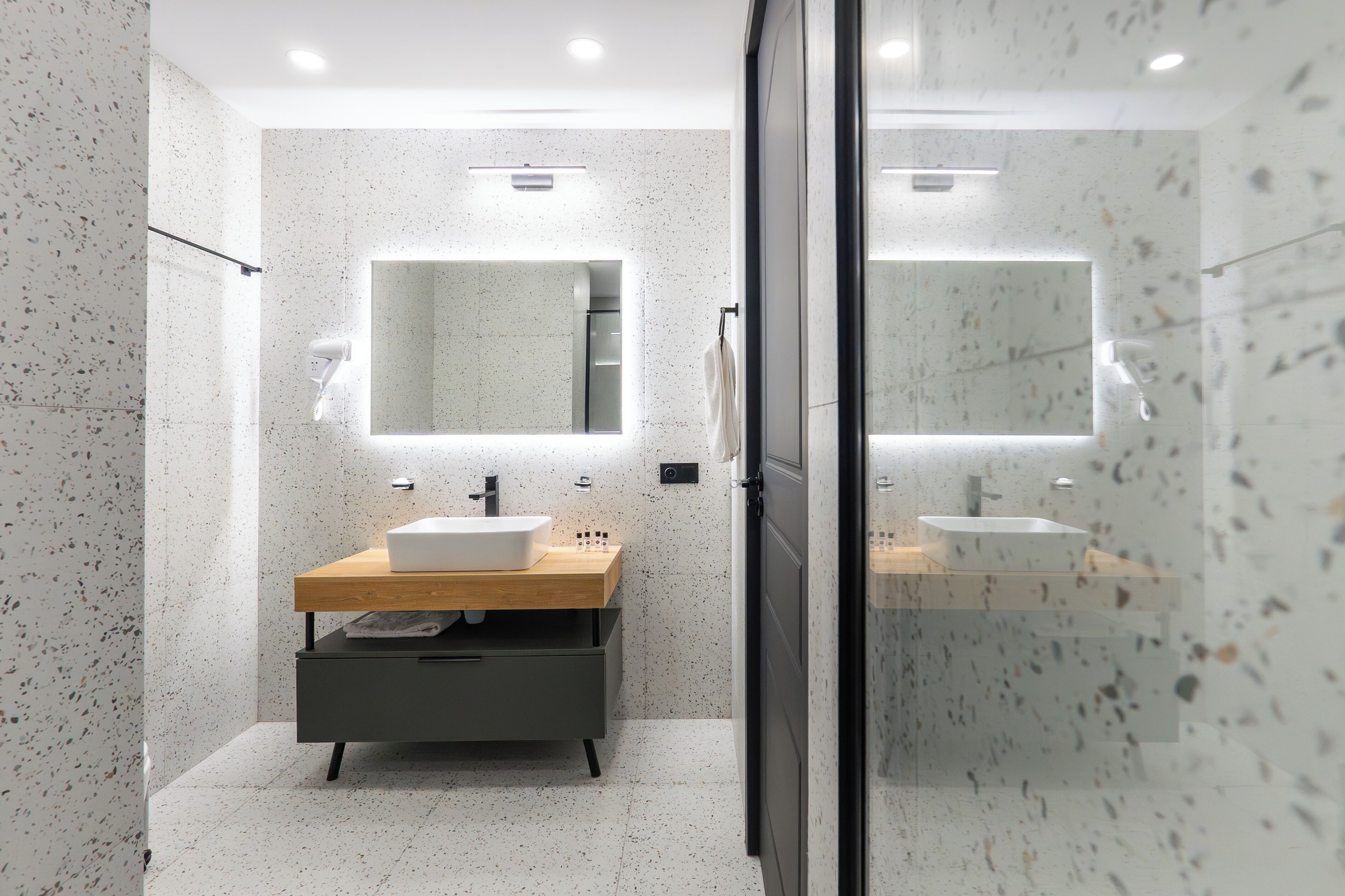 A modern bathroom with a freestanding sink, a mirror, and a towel rack.