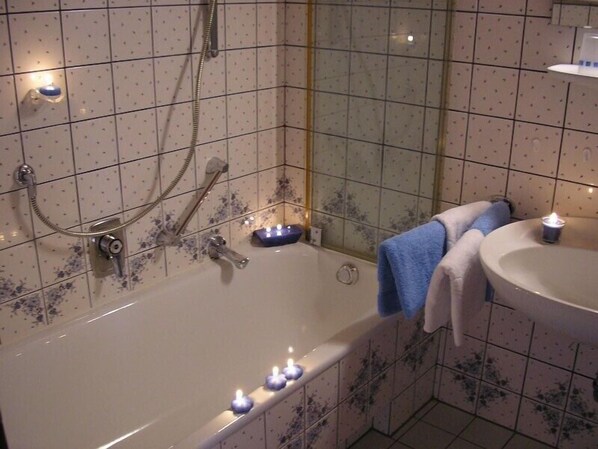 Un baño con bañera, lavabo y espejo.