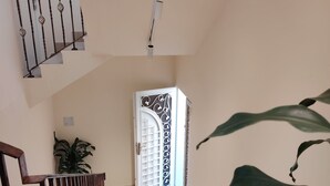 Una escalera con barandilla blanca y una puerta decorativa en la parte superior.