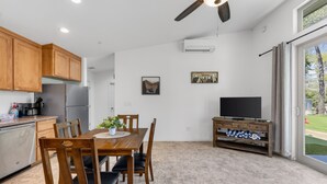 A modern kitchen with wooden cabinets, a built-in refrigerator, and a dining area with a wooden table and chairs. - Waterfront,  family resort, 2 separate units, Sauna, and Jacuzzi/ sleeps 8 (Kernville)