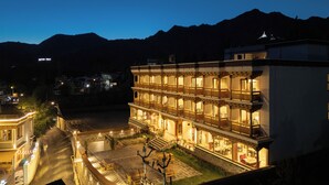 A multi-story building with balconies, a courtyard, and a view of mountains in the background. - Hotel Samaya (Leh)