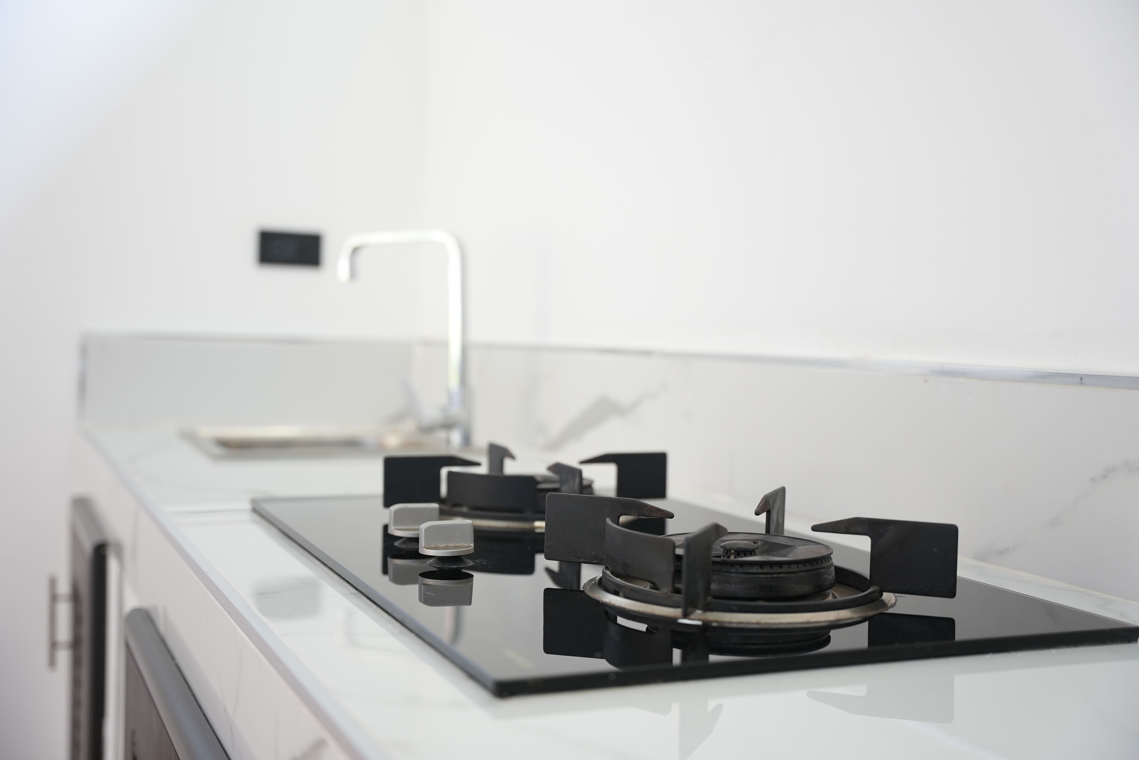 A modern kitchen with a black stovetop and stainless steel appliances.