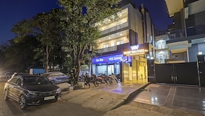 A bank with a sign reading "YES BANK" and a building with a sign "WATCOM WELCOMS". - Hotel Warm Welcome Inn Noida Sector 26 (Noida)