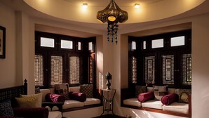 A traditional room with two sofas, a small table, and a hanging lamp.