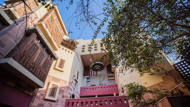 A multi-story building with balconies, a courtyard, and a view of the sky.