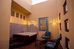 Un área de spa con hidromasaje, asientos e iluminación decorativa.