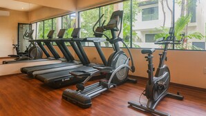 Une salle de sport équipée de tapis de course, d’appareils elliptiques et de vélos d’appartement.