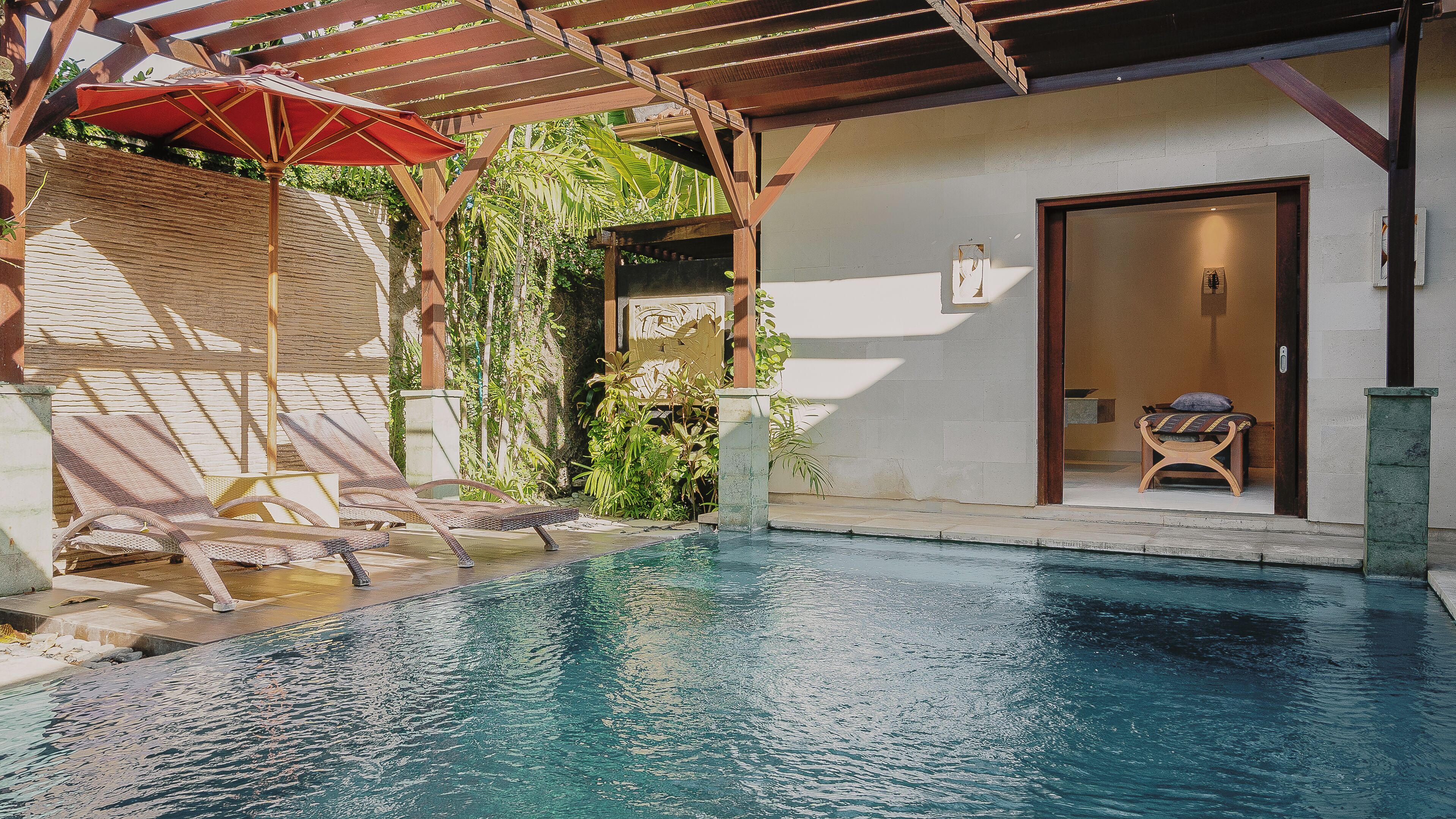 Una piscina al aire libre, sombrillas, tumbonas