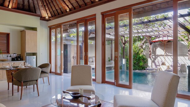Une cuisine moderne avec un coin repas, un espace détente au bord de la piscine et une vue sur la piscine.