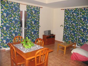 Cozy retreat with a dining area, comfortable bed, and a TV for entertainment.
