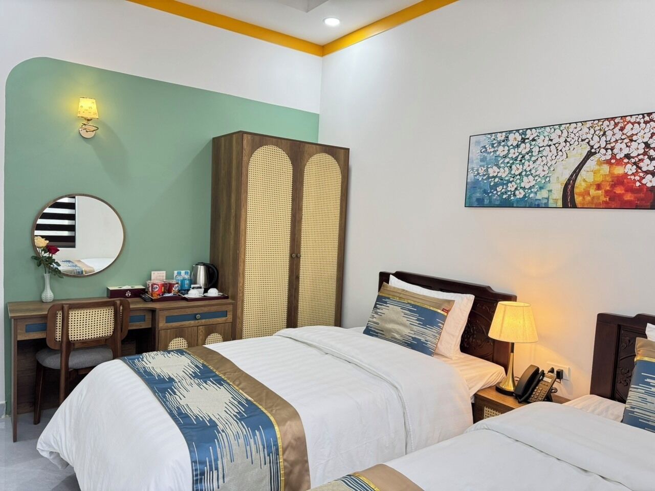 Una habitación de hotel con cama, mesita de noche, lámpara y escritorio con silla.