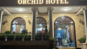 The Orchid Hotel entrance with a prominent sign, arched windows, and columns. - ORCHID Hotel (Lam Vien - Da Lat)