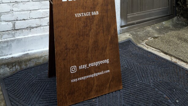 Een bruin bord met de tekst 'EUNPYEONG VINTAGE B&B' en contactgegevens.