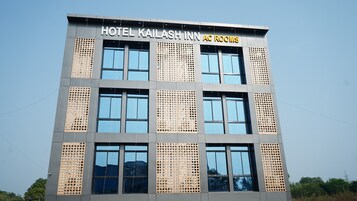 A hotel building with the name "HOTEL KAILASH INN AC ROOMS" on the facade.