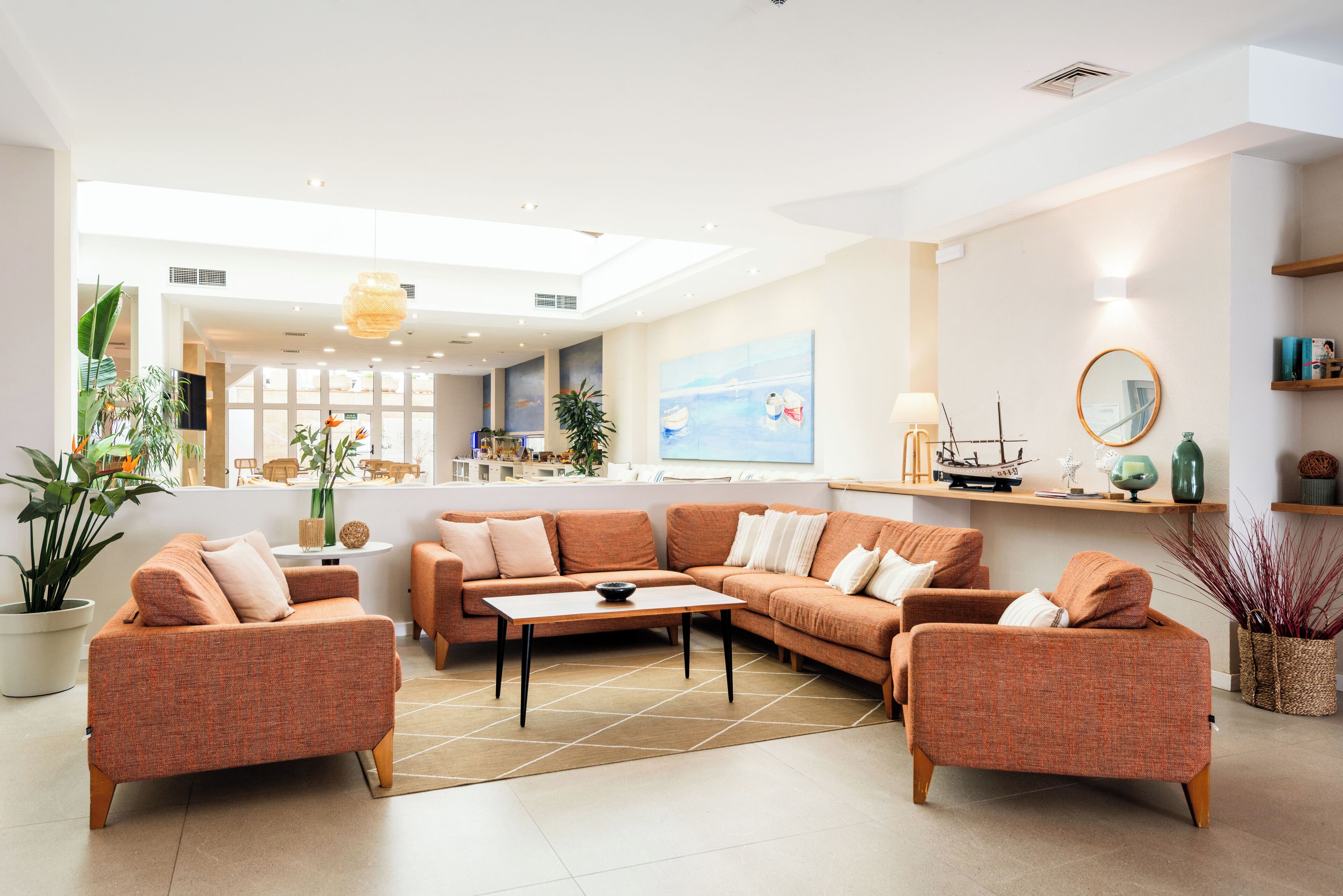 A spacious living area with a large sectional sofa, a coffee table, and a dining area in the background.