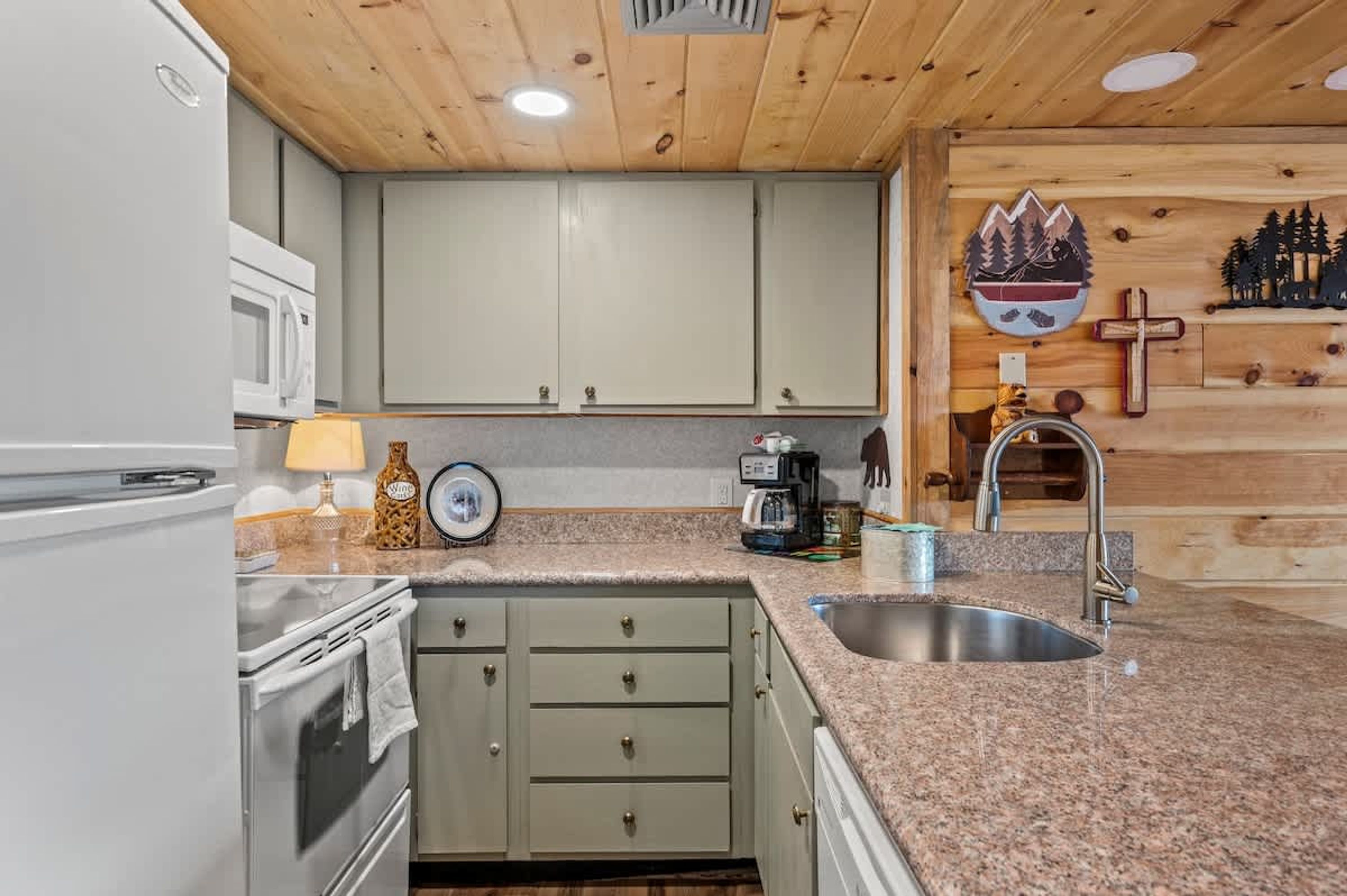 A kitchen with granite countertops, a sink, a stove, and a microwave.